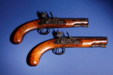 Two 18th century pistols with wooden handles, one of which is marked with the initials R. B.