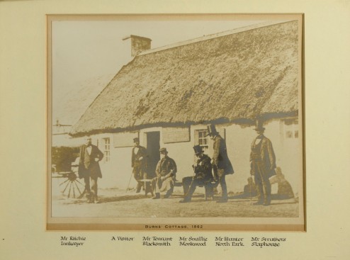 A photograph of Burns Cottage with the Innkeeper and prominent residents.